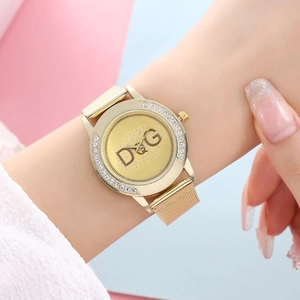 Close-up of rose gold women's watch with mesh strap and rhinestone bezel on wrist