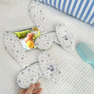 Cute bunny ear sleep mask with lace trim and bear pattern on a white bed sheet
