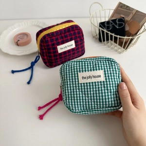 Close-up of quilted checkerboard cosmetic bag with zipper detail and interior divider