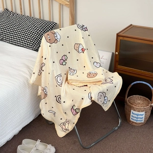 Detail of soft yellow coral fleece blanket featuring cartoon bears and strawberry patterns