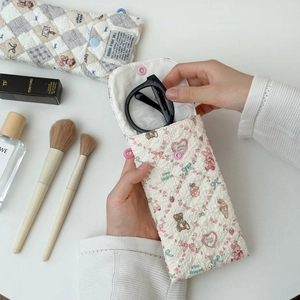 Detailed view of a quilted cream glasses pouch with cute bear and floral patterns