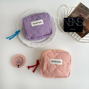 Detail of quilted cotton plaid cosmetic pouches in lilac and pink with woven cord zippers