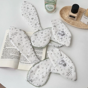 Detail of white cotton eye masks with bunny ears, green lace trim and bear prints
