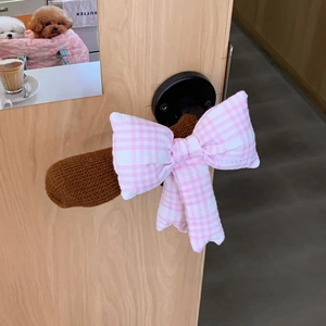 Detail of a brown knitted door handle cover with a pink gingham bow and embroidery