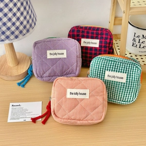 Detailed close-up of quilted plaid cosmetic bags with the jolly house label and colorful zipper