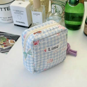 Detail of blue checkered puffer pouch with cute bear pattern and purple zip puller