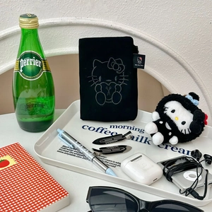 Detail of black cartoon kitty passport holder with embroidery and woven label