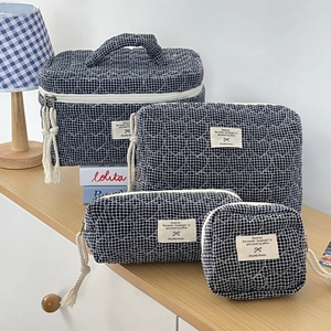 Lot de quatre trousses de maquillage matelassées à motif cœurs et carreaux bleu marine