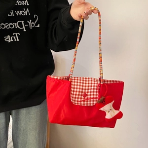 Red plaid tote bag with colorful braided handles and cute plush charm handheld view