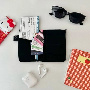 Flat lay of black multifunctional passport holder with credit cards and travel essentials