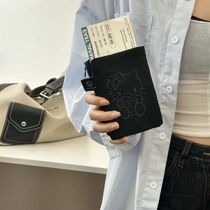 Close-up of black Hello Kitty embossed passport holder held in hand with card detail