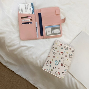 Detail view of pink and beige cartoon cat passport holders with multiple card slots