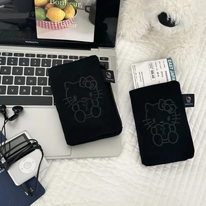 Detail view of black fabric passport holders with cute cartoon character embroidery