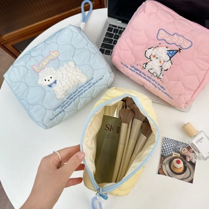 Detail of quilted makeup bags with lamb and puppy embroidery and spacious interior