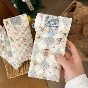 Detail of quilted cartoon sunglasses pouch featuring teddy bear prints and snap button