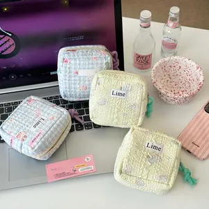Detailed view of quilted cotton cosmetic bags with zip closure and Lime brand label