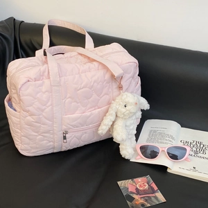 Sac de voyage rose matelassé cœur avec pendentif lapin et sangle pour valise sur noir
