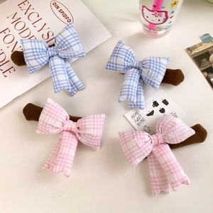 Detail of bow-knot door handle covers with pink and blue plaid patterns in a cozy set