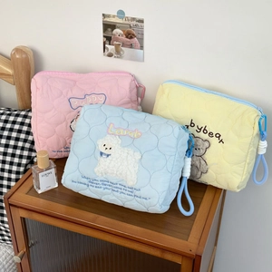 Quilted cotton cosmetic bags in pastel pink, blue, and yellow with animal embroidery details