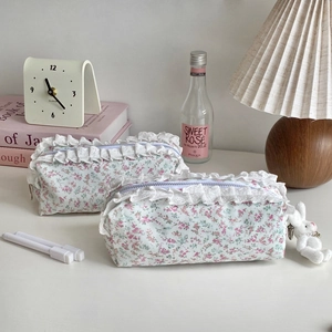 Détail d'une trousse à fleurs en dentelle avec pendentif lapin sur un bureau soigné