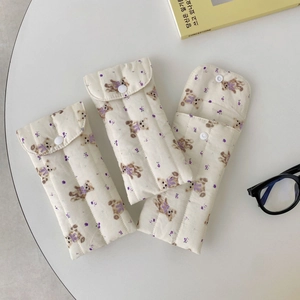 Detail view of quilted floral bear sunglasses pouches with button closure in a 3-piece set