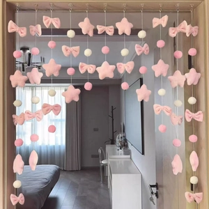 Detailed view of pink plush stars and bows curtain hanging on a bedroom doorframe