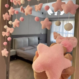 Close-up of pink and white plush star and ball bead curtain for room decoration