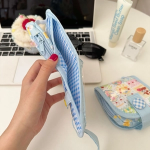 Dettaglio del mini portamonete floreale con fodera a scacchi e scomparti multipli