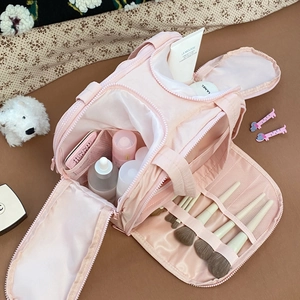 Detail view of pink travel toiletry bag open interior showing makeup brush slots