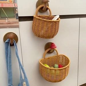 Close-up of woven rattan hanging baskets with mushroom-shaped wooden wall hooks