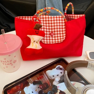 Detail of red checkered canvas tote bag with colorful beaded handles and apple plush charm
