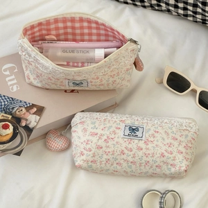 Detail of floral lace pencil case with gold zipper and Rise and Shine tag on fabric