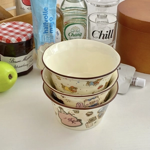 Close-up of stacked cream ceramic bowls with cute cartoon animal illustrations for home use