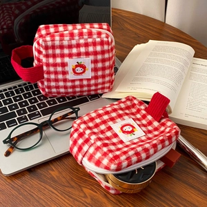 Detail view of red plaid plush makeup bag with kitty embroidery and sturdy top handle