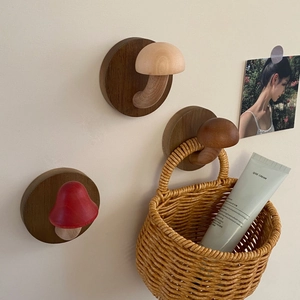 Detailed view of three decorative mushroom wall hooks in varied wood tones and styles