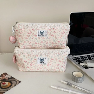Close-up of floral lace pencil case with pink heart charm and Rise and shine label