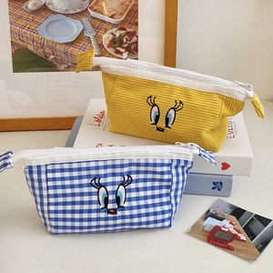 Detail of cute embroidered kingfisher pouches in yellow corduroy and blue plaid cotton