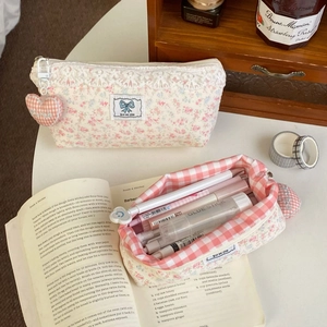 Detailed close-up of floral lace pencil case set with pink inner plaid lining