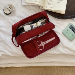 Macro view of burgundy multi-layer nylon pencil case showing mesh pocket storage
