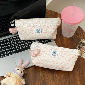 Floral lace pencil case with large capacity and heart pendant on a wooden desk