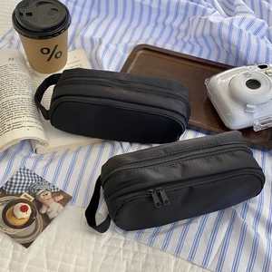 Close-up of black multi-layer stationery bag with durable handle and double zippers