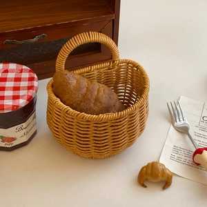 Detail of woven faux rattan storage basket with handle featuring rustic French style decor
