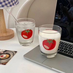 Detail shot of two glass cups with tomato print and Tomato text on a white table