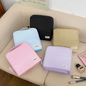 Collection of colorful macaron cosmetic bags on a sofa showing five stylish pastel shades