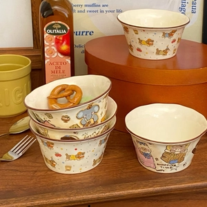 Close-up of cute hand-painted cartoon animal ceramic bowls in a cozy kitchen setting