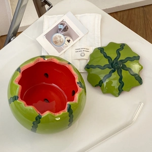 Detail of watermelon-shaped ceramic bowl with lid and internal red glaze with seeds