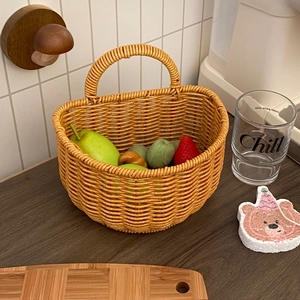 Close-up of a vintage woven storage basket with fruit on a wooden kitchen countertop