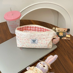 Floral lace pencil case with large capacity and heart pendant on a wooden desk