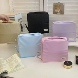 Close-up of five macaron-colored waterproof nylon makeup bags with top handles