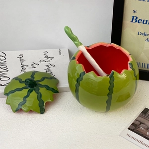 Detail of a ceramic watermelon bowl set including a textured lid and a leaf-shaped spoon
